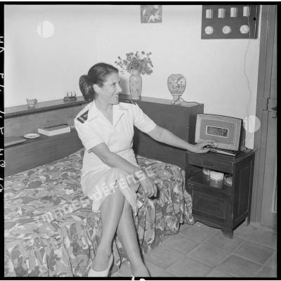 Une femme portant l'uniforme des troupes coloniales dans un appartement du cantonnement des PFAT (personnel féminin de l'armée de Terre).