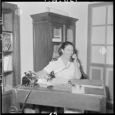Femme portant l'uniforme des troupes coloniales discutant au téléphone dans un bureau du cantonnement des PFAT (personnel féminin de l'armée de Terre).