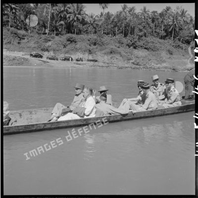 En compagnie d'autorités civiles et militaires, les généraux Ely (au centre) et Salan (tête tournée) traversent le Mékong sur une pirogue à moteur.