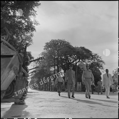 Le général Ely (à gauche), commandant en chef en Indochine, le général Cogny (au centre) et M. Nguyen Huu Tri (à droite) passent le RBCEO (régiment blindé colonial en Extrême-Orient) en revue.