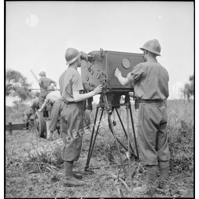 Lors d'une école à feu du 411e RAAA  (régiment d'artillerie antiaérienne) de la DMC (division de marche de Constantine), deux artilleurs utilisent un système de visée et de mesure d'un canon de 40 mm Bofors.