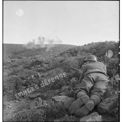 Un élève de l'école des élèves aspirants ou CIEO (Centre d'instruction des élèves officiers) de Cherchell, équipé d'un fusil-mitrailleur 24/29, est en position de tireur couché au cours d'une manoeuvre d'infanterie.