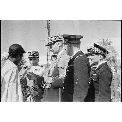 Le général d'armée Henri Giraud, commandant en chef civil et militaire, examine un objet artisanal produit à Bou Saada que lui présente un habitant.