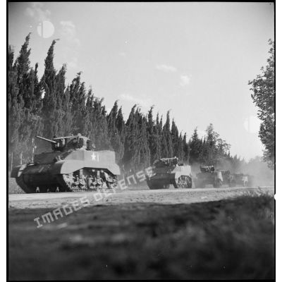 Des chars légers Stuart M5 A1 américains, qui sortent de l'établissement de réparation des engins blindés de Boufarik, partent en convoi vers la gare pour leur embarquement et leur livraison à un régiment de spahis.