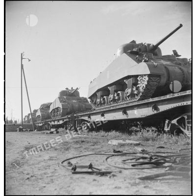 En gare de Boufarik, des chars moyens Sherman M4 A4 américains, destinés au 5e RCA (régiment de chasseurs d'Afrique) de la 1re DB (division blindée), sont embarqués sur un wagon porte-chars.