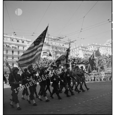 Défilé des drapeaux américain, français et britannique et de leurs gardes lors de la fête de Jeanne d'Arc à Alger.