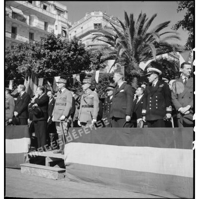 Dans la tribune officielle, les généraux d'armée Henri Giraud, commandant en chef civil et militaire, et Georges Catroux assistent au défilé interallié qui a lieu dans le cadre de la célébration de la fête de Jeanne d'Arc à Alger.