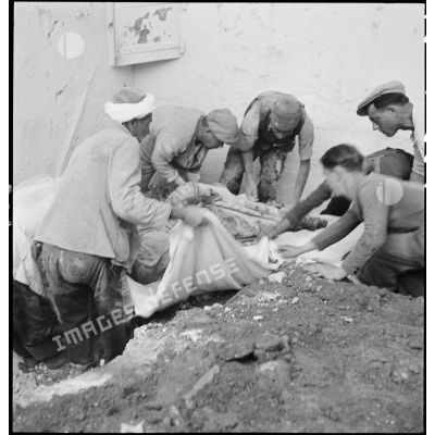 Dégagement du corps d'une victime du bombardement allemand d'Alger dans la nuit du 18 au 19 avril 1943.
