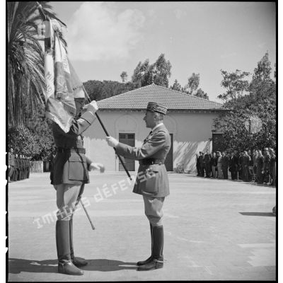 Lors d'une cérémonie, le général d'armée René Prioux, major général des forces terrestres, remet le drapeau de l'EMPNA (Ecole militaire préparatoire nord-africaine) d'Hammam-Righa au colonel Faure, commandant l'école.