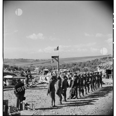 Dans une carrière près de Bizerte, des tirailleurs du 43e RIC (régiment d'infanterie coloniale), prisonniers des Italiens et libérés par le CFA (Corps franc d'Afrique), saluent la montée des couleurs.
