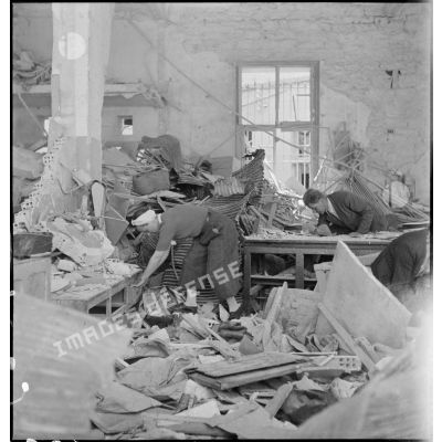 Des civils fouillent les ruines de leur magasin après la libération de la ville de Bizerte par le CFA (Corps franc d'Afrique).