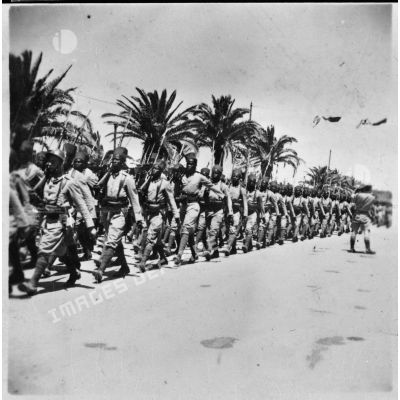 Défilé de tirailleurs sénégalais lors de la cérémonie célébrant la victoire alliée à l'issue de la campagne de Tunisie.