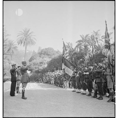Le général d'armée Henri Giraud, commandant en chef civil et militaire, salue les drapeaux alliés et le drapeau du 1er RZ (régiment de zouaves) au Palais d'été d'Alger.
