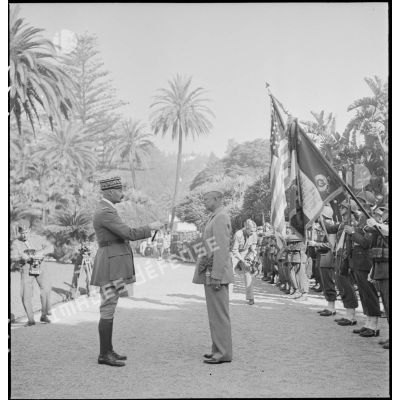 Le général d'armée Henri Giraud, commandant en chef civil et militaire, après avoir remis les insignes de grand-croix de la Légion d'honneur au général Dwight Eisenhower, commandant en chef des forces alliées en Afrique, le frappe du plat de l'épée sur chaque épaule.