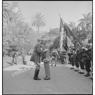 Le général d'armée Henri Giraud, commandant en chef civil et militaire, après avoir remis les insignes de grand-croix de la Légion d'honneur au général Dwight Eisenhower, commandant en chef des forces alliées en Afrique, lui donne l'accolade.