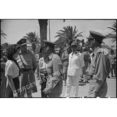 Lors d'une visite en Tunisie, le roi George VI, souverain britannique, félicite une éclaireuse du mouvement scout qui a fait évader des soldats britanniques pendant l'occupation allemande de Tunis.