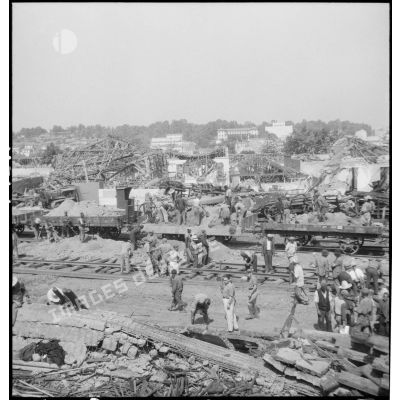 Remise en état des voies ferrées le lendemain d'un bombardement allemand visant la gare de Maison-Carrée.