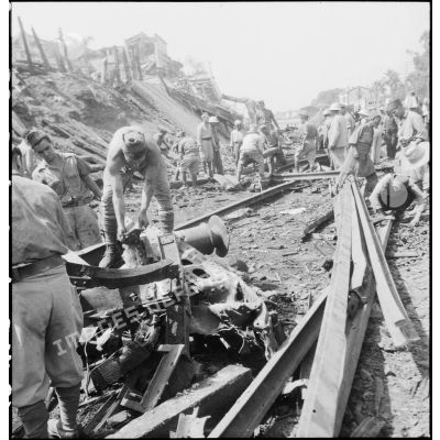 Des soldats déblaient les rails et débris le lendemain d'un bombardement allemand visant la gare de Maison-Carrée.