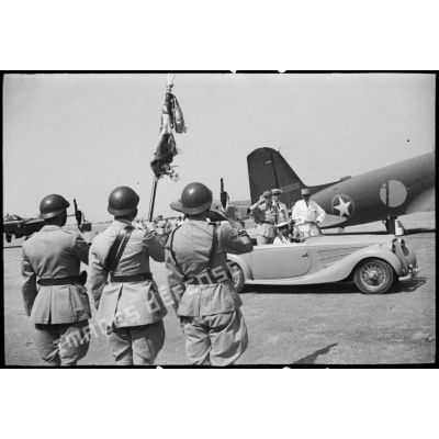 Le général de division Charles Mast, résident général de France en Tunisie, qui quitte l'aérodrome d'El-Aouina de Tunis à bord d'une voiture Delahaye en compagnie de monsieur Lafont, salue un drapeau et sa garde.