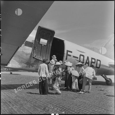 Hommes, femmes et enfants nord-vietnamiens montant à bord d'un avion affrété pour le pont aérien Hanoï-Saigon.