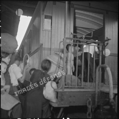 Une famille monte dans le wagon d'un train à quai en gare d'Hanoï.