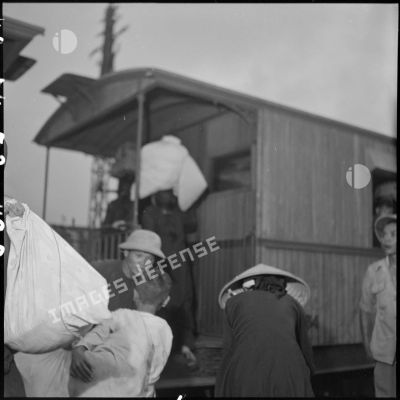 Des réfugiés montent dans un wagon à quai en gare d'Hanoï.