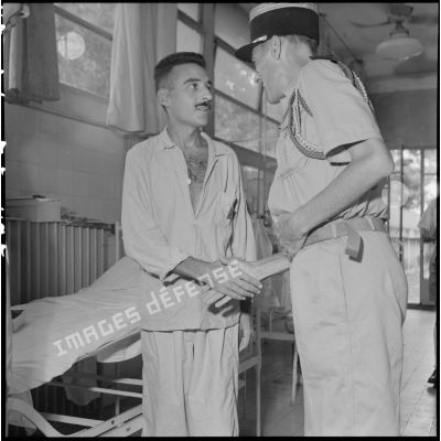 Le colonel Lalande (à droite) serre la main d'un homme hospitalisé à l'hôpital militaire Lanessan.