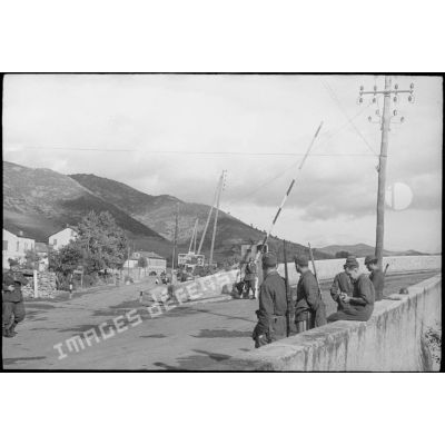 Des soldats italiens contrôlent l'accès d'une route et d'un pont menant probablement à Saint-Florent (intersection des N 197 et N 193, dans la commune de Ponte-Leccia).