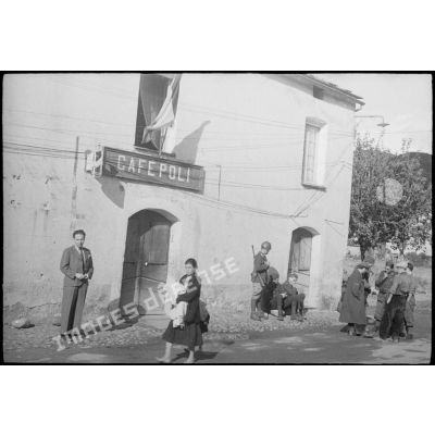 Soldats italiens et population corse près d'un café dans la commune de Ponte-Leccia.