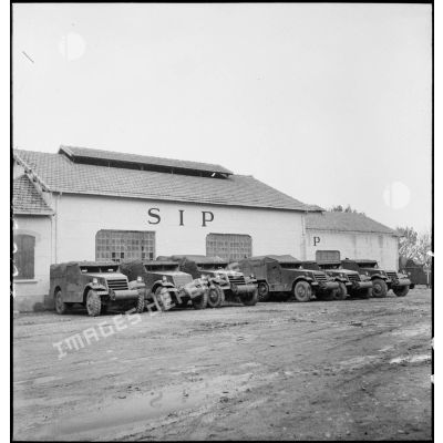 Des scout-car M3A1 et des half-track M3 sont parqués devant un des garages de l'école des élèves aspirants ou CIEO (Centre d'instruction des élèves officiers) de Cherchell à la caserne Dubourdieu.