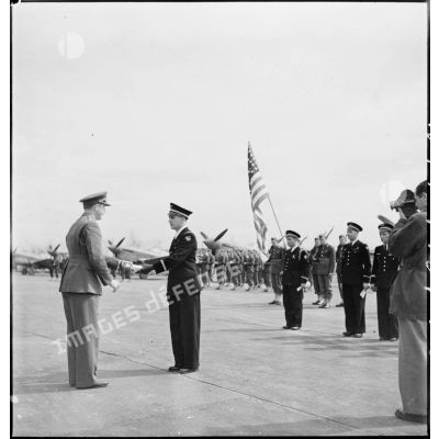 Lors de la cérémonie franco-américaine sur l'aérodrome de Maison-Blanche à Alger en l'honneur du groupe de chasse II/5 La Fayette, un général de brigade de l'armée de l'air américaine décerne l'Air medal au lieutenant Guy Le Stum, pilote du GC II/5.