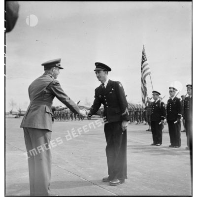 Lors de la cérémonie franco-américaine sur l'aérodrome de Maison-Blanche à Alger en l'honneur du groupe de chasse II/5 La Fayette, un général de brigade de l'armée de l'air américaine décerne l'Air medal au sergent-chef Jean Gisclon, pilote du GC II/5