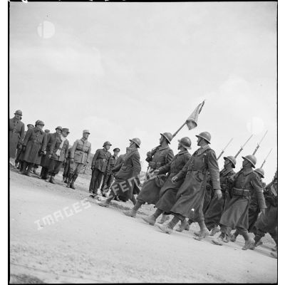 Défilé d'un détachement d'une unité de tirailleurs devant les autorités lors de l'inauguration du monument érigé à la mémoire du général de division Marie-Joseph Welvert, commandant la DMC (division de marche de Constantine), décédé au cours de la campagne de Tunisie.