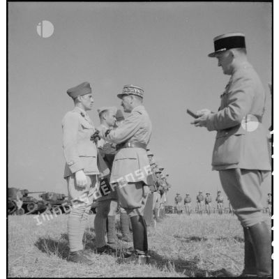 Au cours d'une prise d'armes, le général de corps d'armée Louis Koeltz, commandant le 19e CA (corps d'armée), décore des récipiendaires, ici un lieutenant, du 5e RCA (régiment de chasseurs d'Afrique), qui se sont distingués au cours de la campagne de Tunisie.