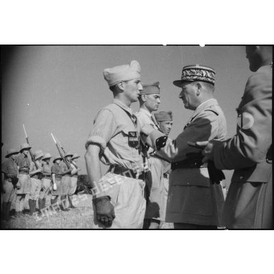 Au cours d'une prise d'armes, le général de corps d'armée Louis Koeltz, commandant le 19e CA (corps d'armée), décore des récipiendaires, ici un capitaine du 5e RCA (régiment de chasseurs d'Afrique), qui se sont distingués au cours de la campagne de Tunisie.