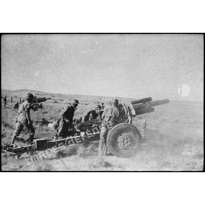 Tir de barrage d'une batterie d'obusiers de 105 mm M2 du 64e RAA (régiment d'artillerie d'Afrique) au cours d'une manoeuvre du CEF (corps expéditionnaire français), avant l'engagement sur le front italien.