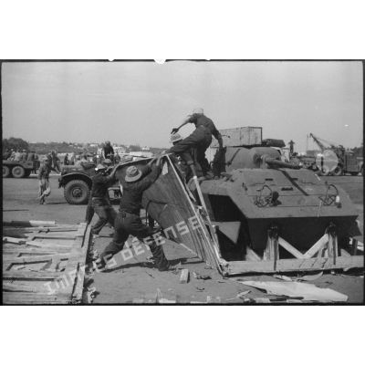 Une automitrailleuse M8 (ou light armored car) est sortie de sa caisse de transport par une équipe de montage sur le port de Casablanca.