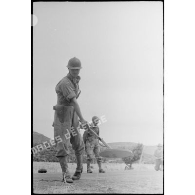 Exercice de déminage avec un détecteur de mines, type poêle à frire, pendant une manoeuvre du CEF (corps expéditionnaire français).