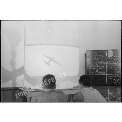 Des artilleurs des FTA (forces terrestres antiaériennes) du CEF (corps expéditionnaire français) apprennent à reconnaître les avions ennemis lors de projections de silhouettes sur un écran.