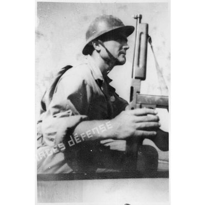 Portrait d'un soldat du CEFI (corps expéditionnaire français en Italie) équipé d'un pistolet-mitrailleur Thompson M1 lors d'un exercice de débarquement sur une plage.