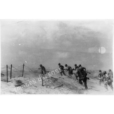 Des soldats du CEFI (corps expéditionnaire français en Italie) progressent sur une plage lors d'un exercice de débarquement.