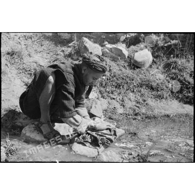 Un goumier du 11e tabor du 4e GTM (groupe de tabors marocains) lave son linge pendant un moment de repos lors d'une manoeuvre du CEF (corps expéditionnaire français).