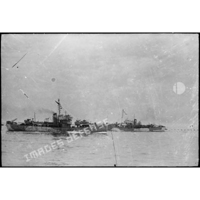 Des navires d'escorte accompagnant un convoi appareillent du port d'Alger à destination de la Corse.