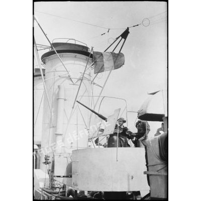 Des marins, servants d'un canon de DCA (défense contre-avions) sont à leur poste de combat à bord d'un des navires d'escorte du convoi à destination de la Corse.