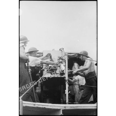 Des marins canonniers sont à leur poste de combat sur un des navires du convoi à destination de la Corse.