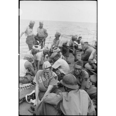 Des tirailleurs du 1er régiment de tirailleurs marocains (RTM) sont rassemblés sur le pont avant d'un torpilleur ou contre-torpilleur à destination de  la Corse.