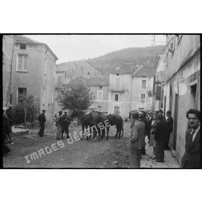 Des soldats italiens se trouvent dans une rue de la commune, au milieu de la population civile.