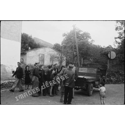 Des habitants du village de Patrimonio accueillent l'équipage d'une jeep Ford GPW (probablement du 4e régiment de spahis marocains).