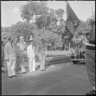 Le général de Castries, M. le Gouverneur du Nord-Vietnam, le général Cogny et M. Bordaz devant le drapeau français.