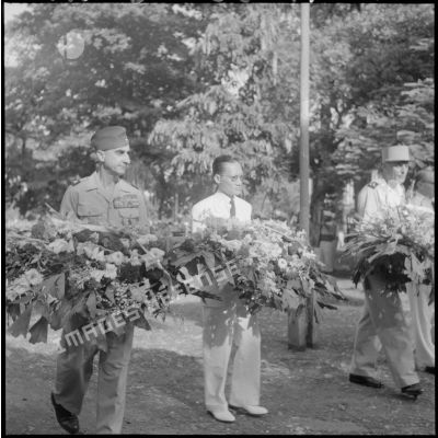 Le général de Castries, M. le Gouverneur du Nord-Vietnam et le général Cogny s'aprêtent à déposer des gerbes de fleurs.